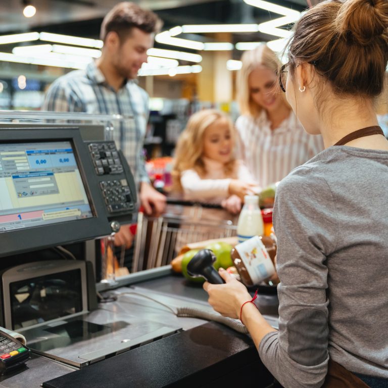 Beautiful family standing at the cash counter